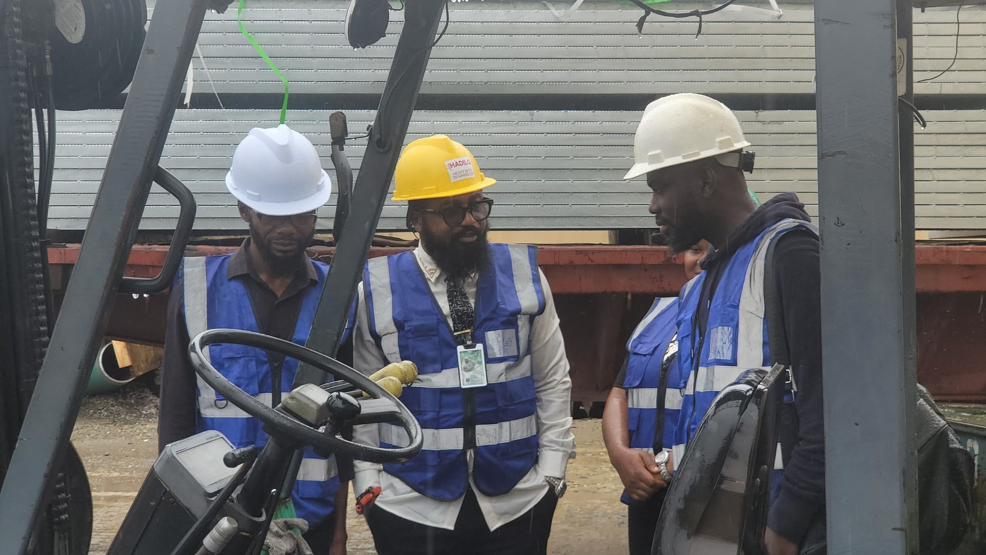 HADILO director briefing two trainees in blue reflective vests beside a forklift