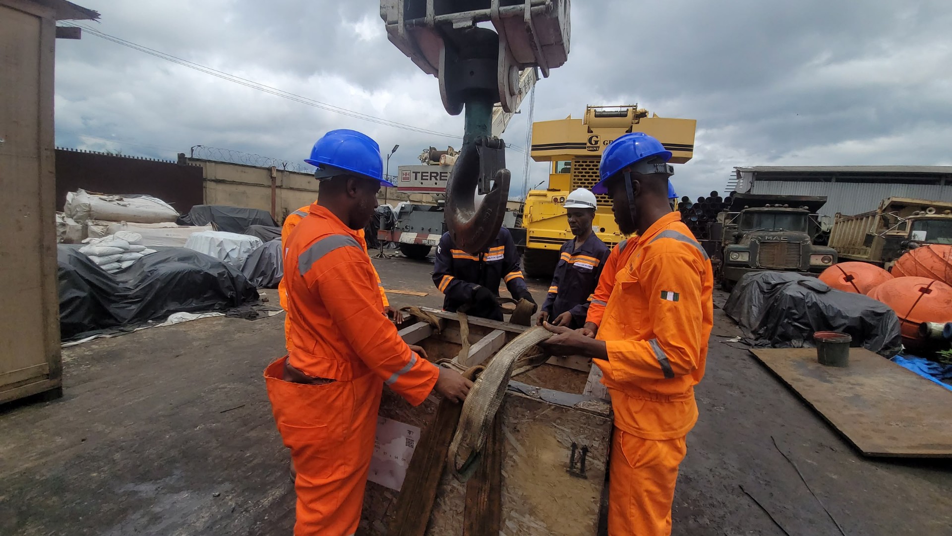 HADILO crew inspecting rigging shackle beneath a Terex mobile crane hook