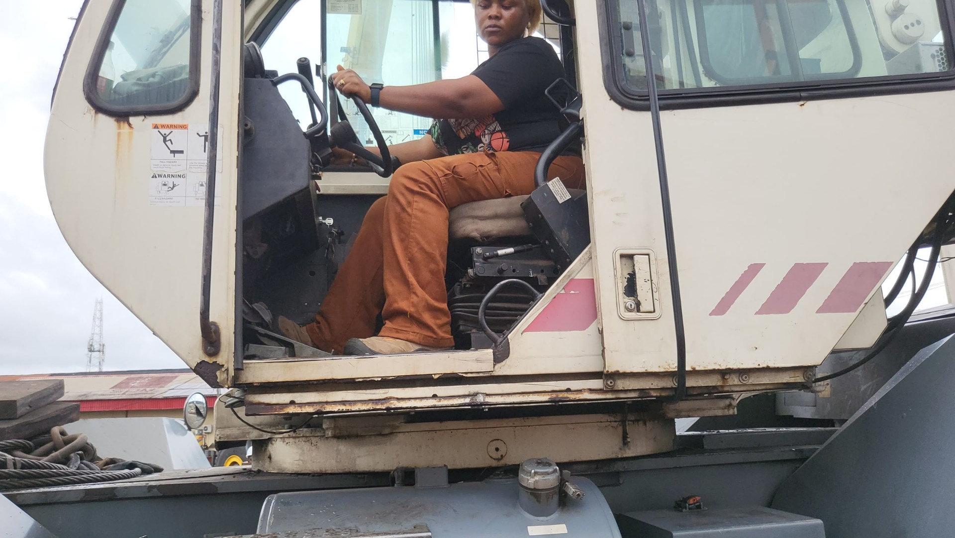 Female HADILO trainee at the controls of a mobile crane cabin