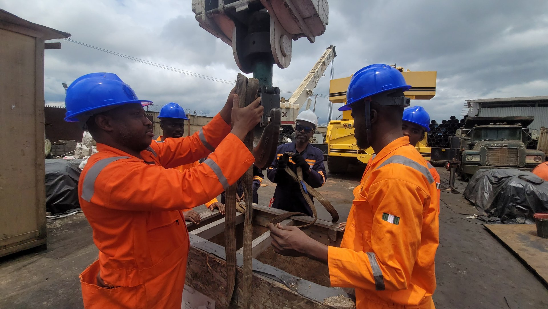 Two HADILO trainees inspecting rigging slings on a crane hook